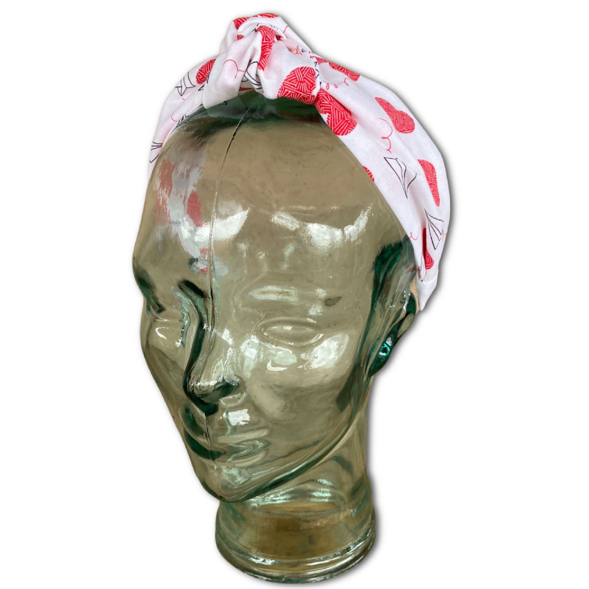 glass head mannequin wearing a valentine themed headband that features large red hearts and paper airplanes